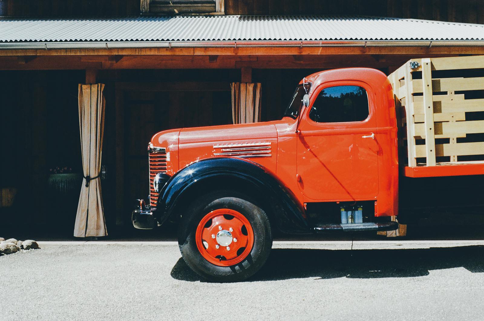 Orange Stake Truck Parked Beside Brown Building